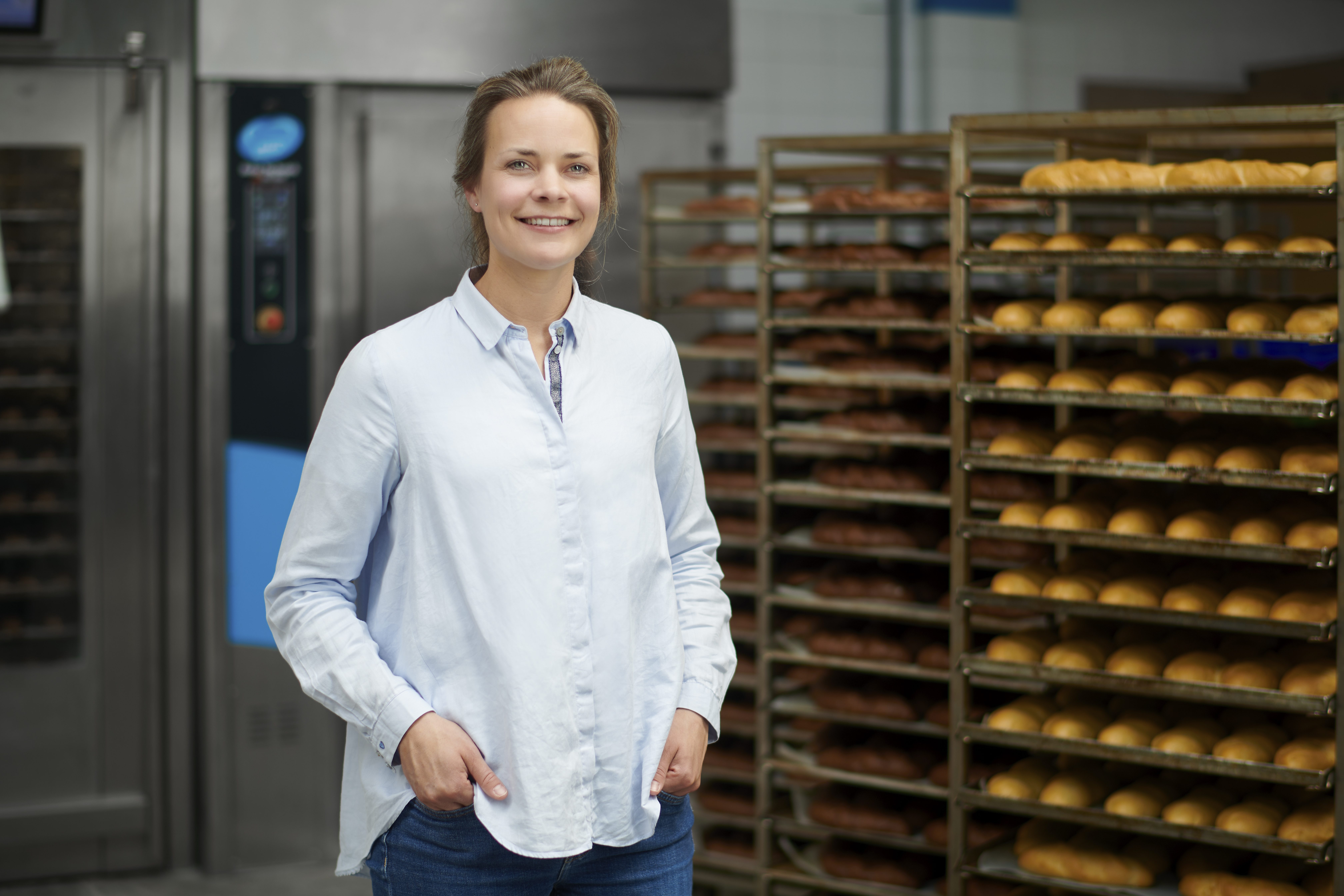 Een vertegenwoordiger van Bakkertje Bol poseert bij broodovens.