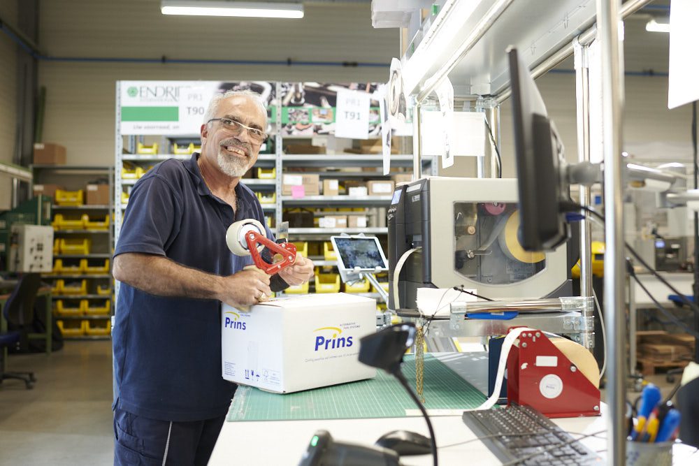 Een medewerker van Prins plakt een doos dicht.