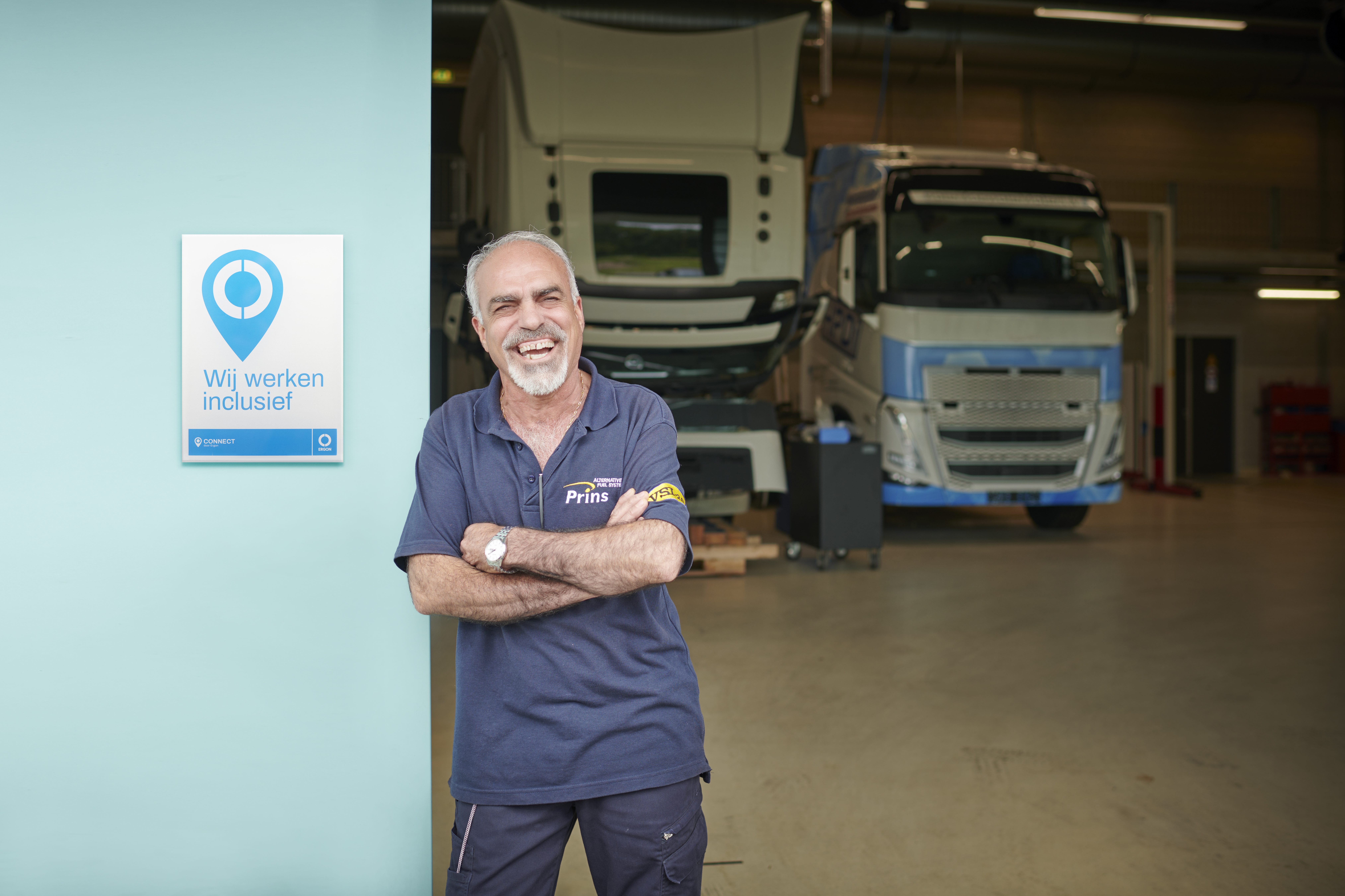 Een medewerker van Prins poseert in een deuropening naast een 'Ergon Connect' certificaat.