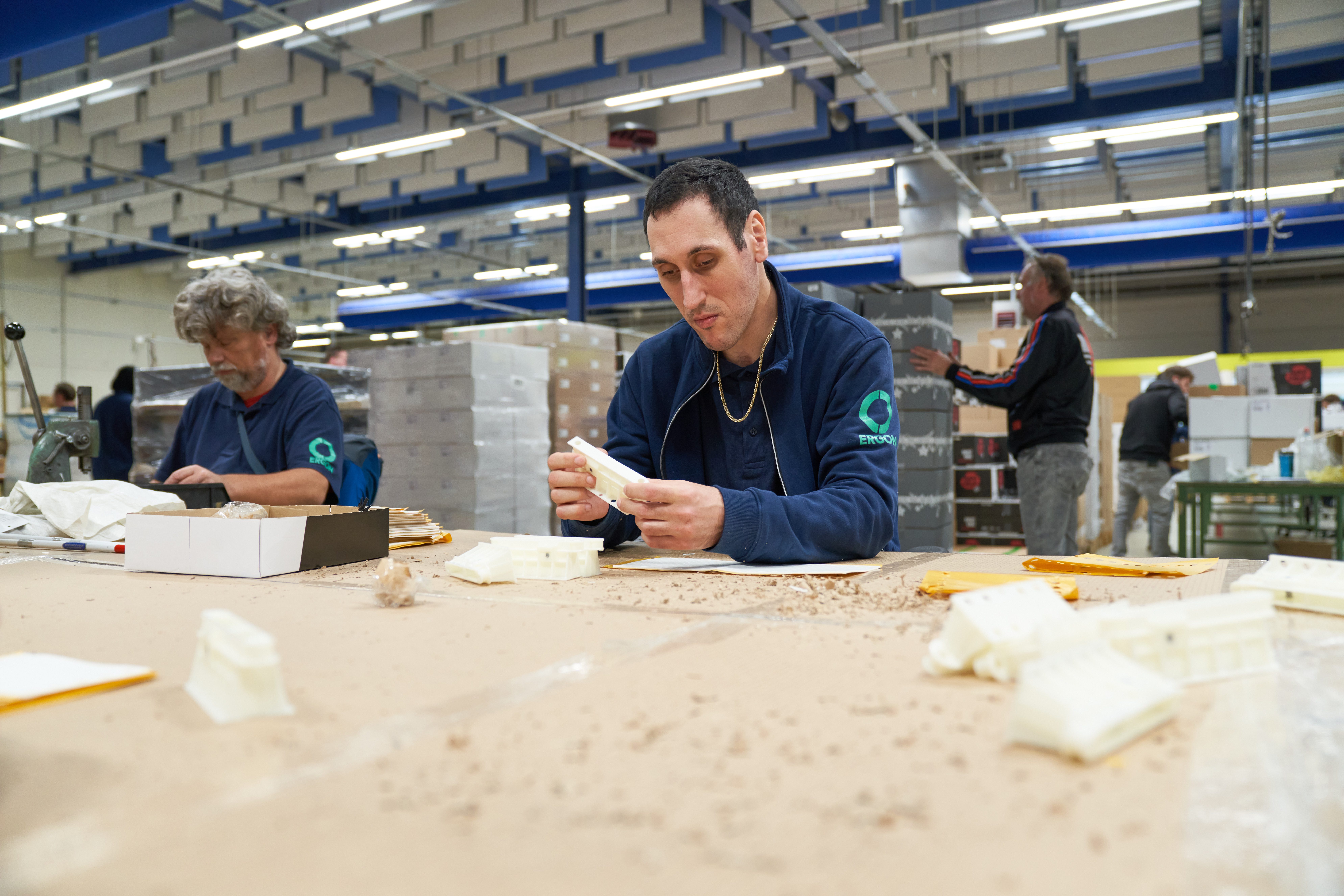 Medewerkers van Ergon Productie zijn bezig met inpakwerkzaamheden.